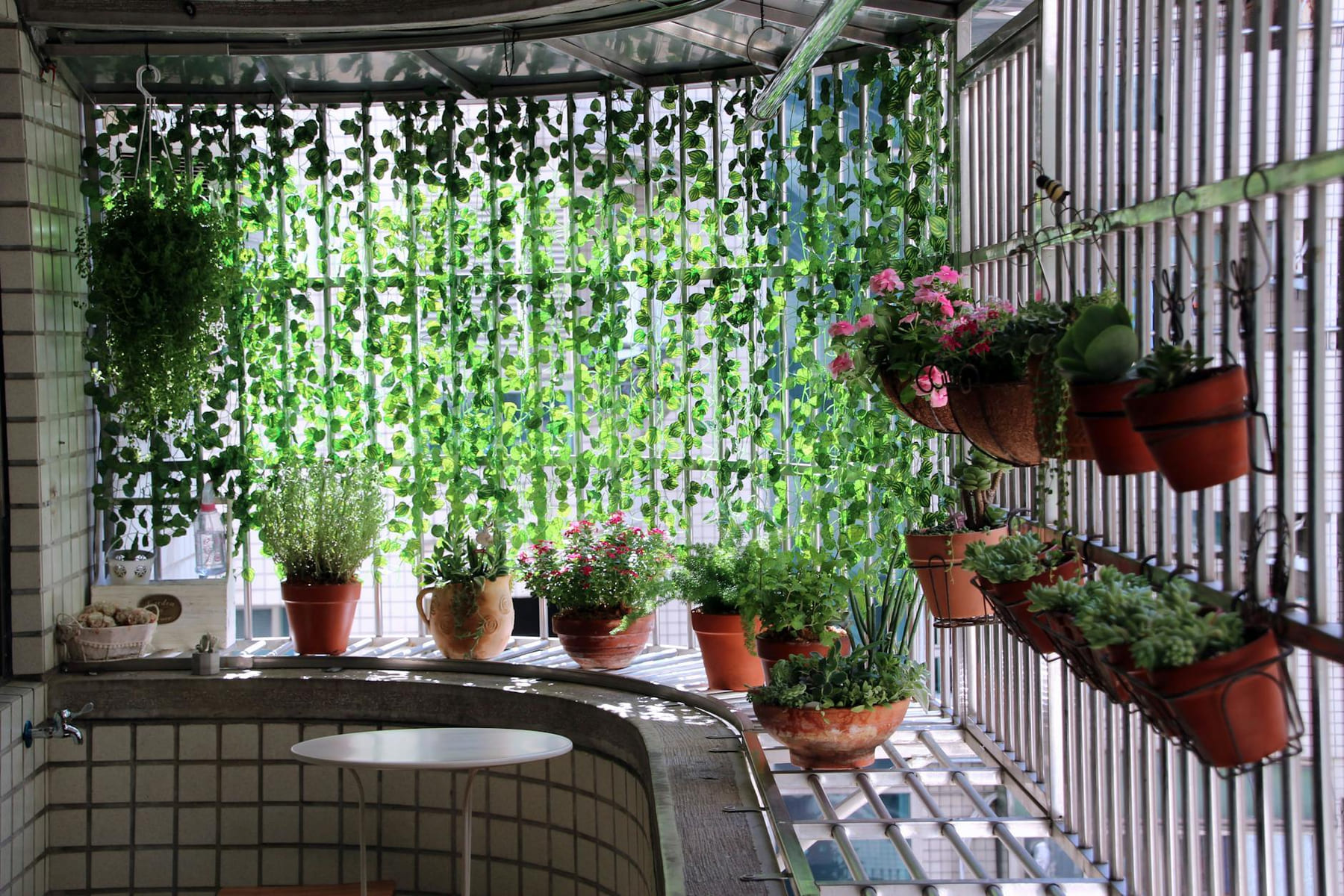 Cozy balcony decorated with hanging and potted plants, ideal for relaxation. on Urban Sprout Corner